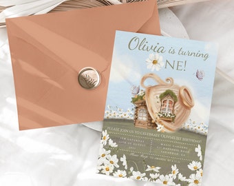 May include: A light blue and white birthday invitation featuring a teapot house illustration. The text reads "Olivia is turning one!" and includes details for a party at Magic Gardens on 1st August 2023.