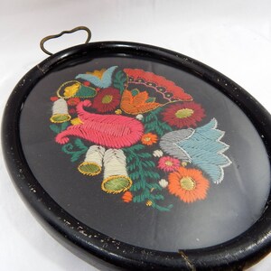 May include: A black wooden tray with a glass insert featuring a colorful embroidered floral design. The embroidery includes pink, blue, green, yellow, and red flowers.