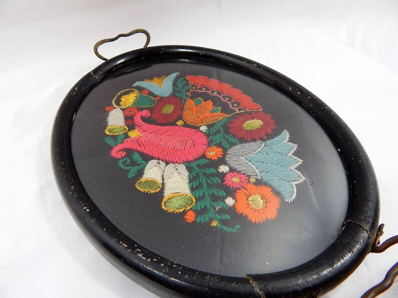 May include: A black wooden tray with a glass insert featuring a colorful embroidered floral design. The embroidery includes pink, blue, green, yellow, and red flowers.