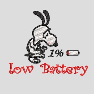 May include: An embroidered design featuring a cartoon dog with black ears and a white body, looking dejected. The text "1%" and a battery icon are next to the dog. Below, the words "Low Battery" are written in red script.