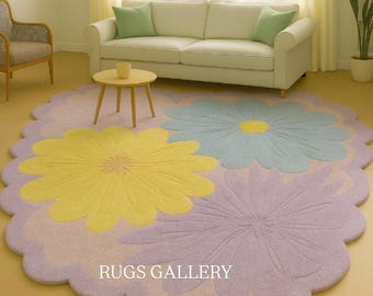 May include: A large, floral-shaped rug with a scalloped edge. The rug features three large flower designs in yellow, blue, and purple, set against a light purple background. The text "RUGS GALLERY" is visible.