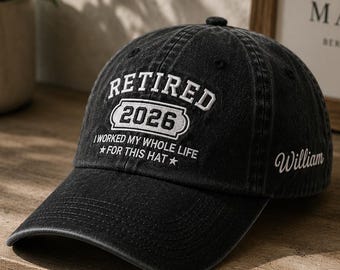 Puede incluir: Gorra de béisbol negra con la palabra "RETIRED" encima de "2026" en letras blancas. El texto "I WORKED MY WHOLE LIFE FOR THIS HAT" está debajo del año. El nombre "William" está bordado en el lateral.