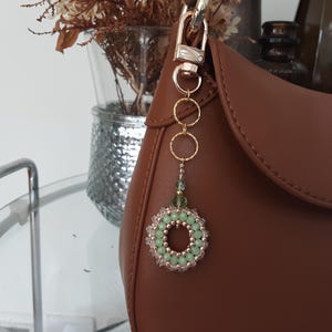 Dije de cristal para bolso. Este brillante dije verde jade es el regalo perfecto y realza cualquier bolso. Incluye envoltorio de regalo.