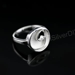 May include: A silver ring with a circular design featuring a wave-like pattern. The ring is set against a black background, with the text "SilverDIY" visible in the background. The ring's design is modern and minimalist.