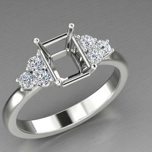 May include: A silver-toned ring setting featuring a central rectangular prong mount designed for a gemstone. The band is accented on both sides by a cluster of three small, round, clear, faceted stones set into the metal shoulders of the ring.