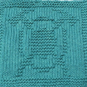 May include: A teal blue knitted dishcloth with a woven pattern.
