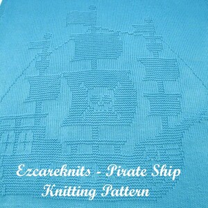 K&ouml;nnte beinhalten: Eine blaue Strickdecke mit einem wei&szlig;en Strickmuster eines Piratenschiffs. Die Decke tr&auml;gt den Text "Ezcareknits - Pirate Ship Knitting Pattern" unten.