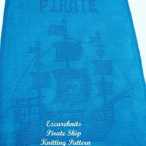 K&ouml;nnte beinhalten: Eine blaue gestrickte Babydecke mit einem wei&szlig;en gestrickten Piratenschiff-Design. Die Decke hat oben das Wort "PIRATE" und unten den Text "Ezcareknits Pirate Ship Knitting Pattern".