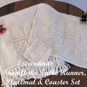 May include: A set of white crocheted snowflake table runner, placemat, and coasters. The set features a delicate snowflake design and a fringe border.