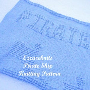 K&ouml;nnte beinhalten: Eine hellblaue gestrickte Babydecke mit dem Wort "Pirate" in erhabenen Lettern. Die Decke zeigt au&szlig;erdem ein gestricktes Schiffsmuster. Der Text "Ezcareknits Pirate Ship Knitting Pattern" ist in Wei&szlig; auf die Decke gedruckt.