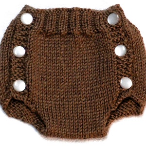 以下が含まれることがあります： 白いボタンが付いた茶色のニット製ベビーおむつカバー