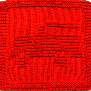 May include: A red knitted dishcloth with a simple design of a truck. The truck is made with a raised stitch pattern.