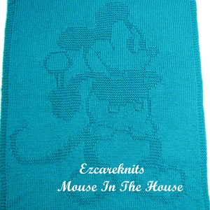 Può includere: Una coperta di lana blu turchese con un contorno bianco di una casa e il testo "Ezcareknits Mouse In The House".