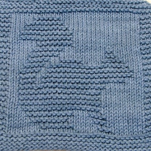 May include: A blue knitted dishcloth with a geometric pattern. The cloth is made with a simple stitch and has a textured surface.