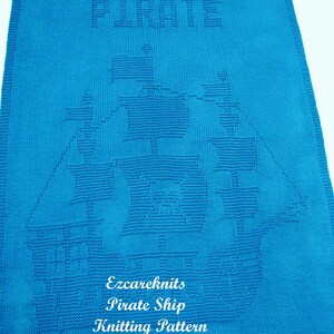 K&ouml;nnte beinhalten: Eine blaue gestrickte Babydecke mit einem wei&szlig;en gestrickten Piratenschiff-Design. Die Decke hat oben das Wort "PIRATE" und unten den Text "Ezcareknits Pirate Ship Knitting Pattern".