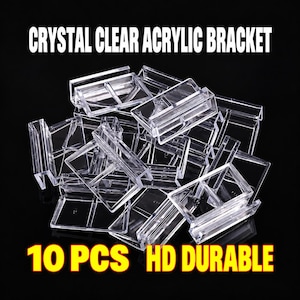 Op de afbeelding: Een verzameling van 10 doorzichtige acrylbeugels met een rechthoekig ontwerp. De tekst CRYSTAL CLEAR ACRYLIC BRACKET en 10 PCS HD DURABLE wordt weergegeven in witte en gele letters tegen een zwarte achtergrond, wat de productkenmerken benadrukt.