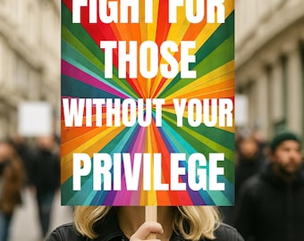 May include: A sign with the text "FIGHT FOR THOSE WITHOUT YOUR PRIVILEGE" in white capital letters. The sign has a rainbow-colored radial design. The sign is held up in a crowd of people.