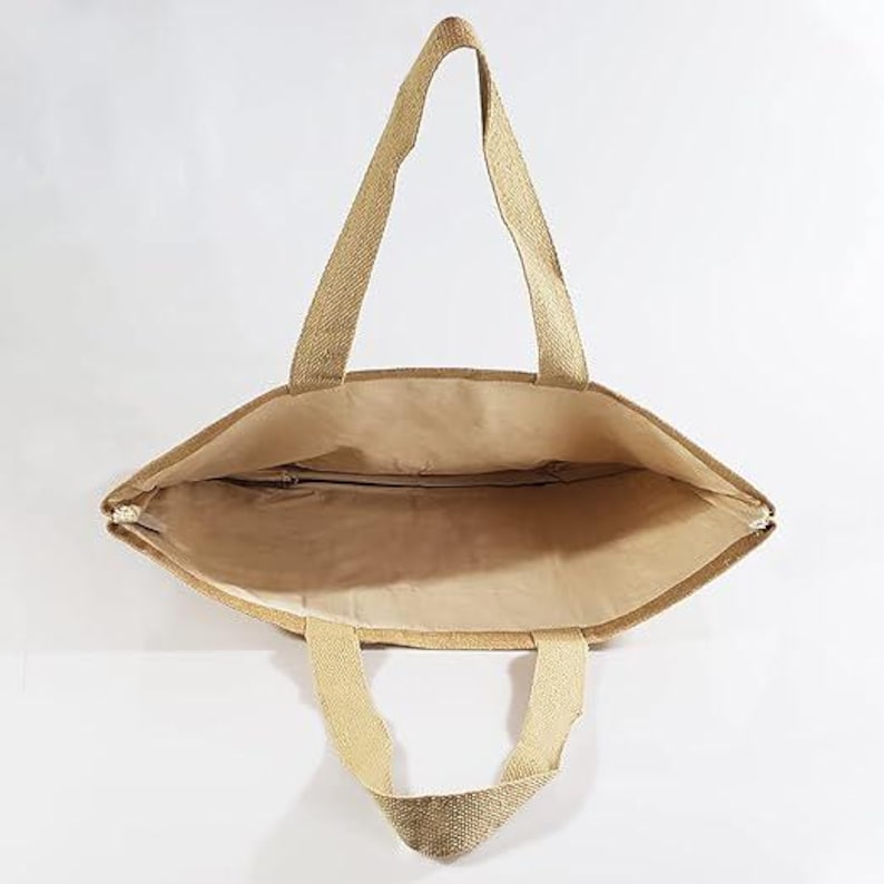 May include: A beige tote bag with two long handles and two shorter handles. The bag is made of a woven material and has a zippered closure. The interior of the bag is a lighter beige colour.