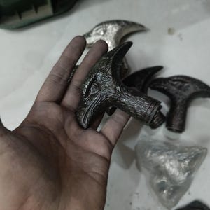 Könnte beinhalten: Eine Sammlung dekorativer Gehstöcke mit Adlerkopf-Motiv. Die Griffe sind überwiegend dunkelgrau mit metallischen Akzenten und zeigen detaillierte Federn und Schnäbel. Mehrere Teile sind sichtbar, was auf ein Set oder eine Auswahl hindeutet.