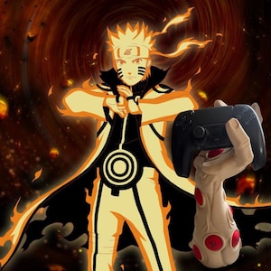 Peut inclure: Une manette de jeu noire tenue par un support beige en forme de main stylisée avec des accents rouges. L'arrière-plan présente une illustration vibrante orange et noire de style anime d'un personnage en pose dynamique.