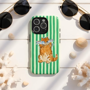 May include: A green and white striped phone case with a watercolour illustration of a ginger cat holding fish. The case is surrounded by sunglasses, seashells, and coral on a white surface.