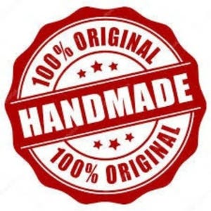 Op de afbeelding: Een rood en wit cirkelvormig embleem met de woorden "HANDMADE" en "ORIGINAL" in een vetgedrukte lettertype. De tekst "100%" is ook opgenomen. Het embleem heeft een geschulpte rand en drie kleine sterren.