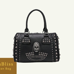 May include: Black handbag with silver-tone studs and a skull design. The bag has a top handle and a rectangular shape. The text "EllaBliss Woman Bag" is visible in the lower left corner.