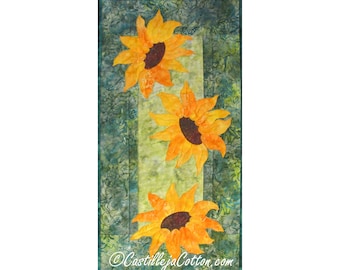 Könnte beinhalten: Eine Steppdecke mit grünem Hintergrund und drei gelben Sonnenblumen. Die Sonnenblumen sind vertikal in einer Reihe angeordnet. Die Steppdecke ist aus Stoff gefertigt und hat eine gesteppte Textur.