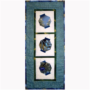 Może przedstawiać: Wiszący obraz z trzema niebieskimi i złotymi latarniami z kwiatowymi wzorami na białym tle. Latarnie są oprawione w zielone i niebieskie ramki.