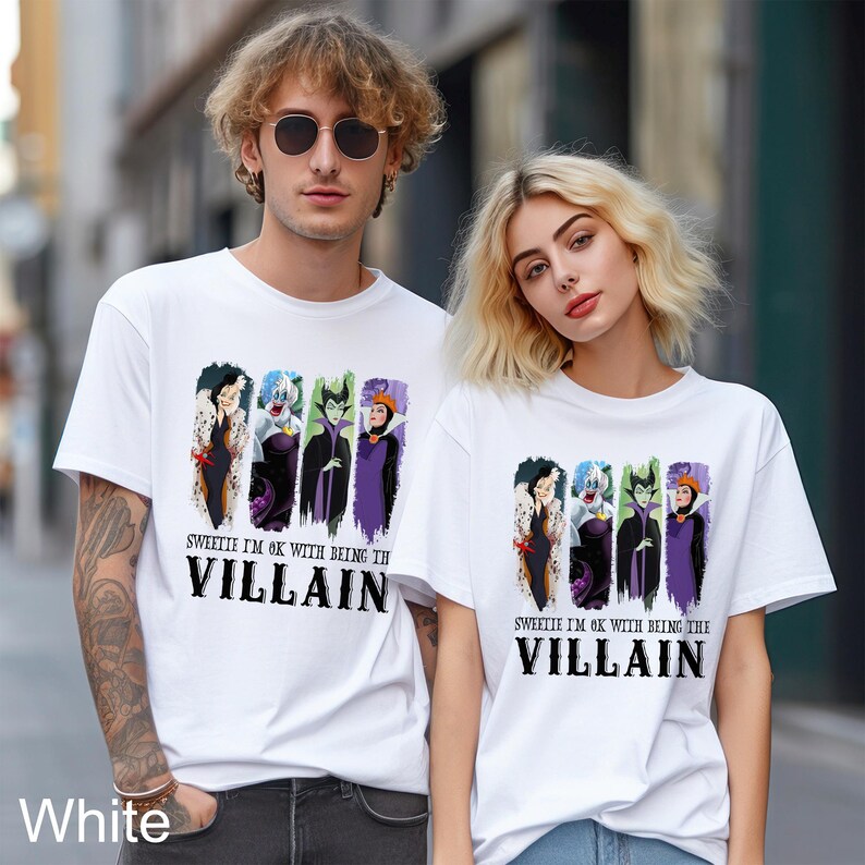 Puede incluir: Dos camisetas blancas con un dise&ntilde;o de villanas de Disney, incluyendo a Cruella de Vil, &Uacute;rsula, Mal&eacute;fica y la Reina Malvada, con el texto "SWEETIE I'M OK WITH BEING THE VILLAIN".