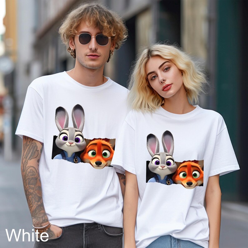 May include: White t-shirts featuring a graphic of Judy Hopps and Nick Wilde from Zootopia. The cartoon characters are peeking out from a torn rectangle. The word "White" is printed at the bottom of the image.