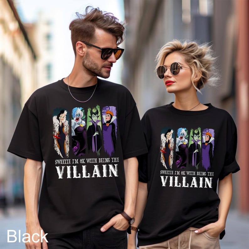 Puede incluir: Camisetas negras con un gr&aacute;fico de villanos de Disney: Cruella de Vil, &Uacute;rsula, Mal&eacute;fica y la Reina Malvada. El texto "SWEETIE I'M OK WITH BEING THE VILLAIN" est&aacute; impreso debajo. Las camisetas son usadas por dos personas.