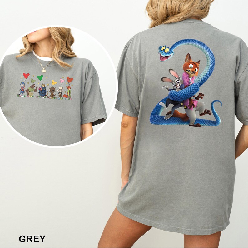 K&ouml;nnte beinhalten: Graues T-Shirt mit einem farbenfrohen Cartoon-Design auf der Vorder- und R&uuml;ckseite. Das Frontdesign zeigt eine Reihe von Cartoon-Charakteren mit herzf&ouml;rmigen Luftballons. Das R&uuml;ckendesign zeigt eine blaue Schlange, die sich um Cartoon-Charaktere windet.