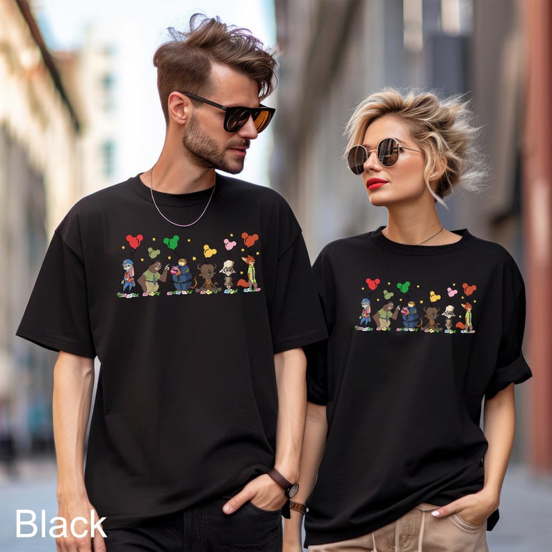 May include: Black t-shirts with a cartoon design of characters and hearts. The shirts are worn by two people. The word "Black" is printed at the bottom left of the image.