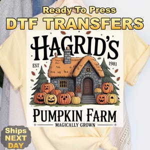 May include: A yellow t-shirt featuring a DTF transfer design. The design includes the text "Hagrid's Pumpkin Farm" with a cottage illustration, pumpkins, and the text "Magically Grown".