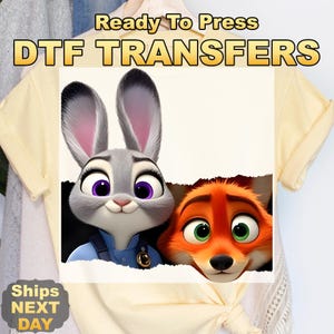 May include: DTF TRANSFERS image featuring Judy Hopps and Nick Wilde from Zootopia. The image includes the text "Ready To Press" and "Ships Next Day". The characters are a gray rabbit and an orange fox with large eyes.