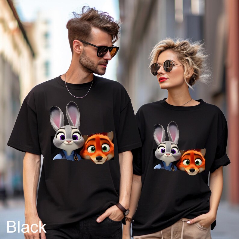 May include: Black t-shirts featuring a cartoon image of Judy Hopps and Nick Wilde from Zootopia. The graphic shows the characters peeking out from a pocket. The word "Black" is printed at the bottom of the image.