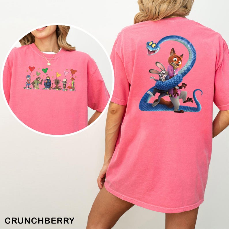 K&ouml;nnte beinhalten: Ein pinkfarbenes T-Shirt mit Cartoon-Grafiken auf der Vorder- und R&uuml;ckseite. Die vordere Grafik zeigt Zeichentrickfiguren, die herzf&ouml;rmige Ballons halten. Die hintere Grafik zeigt einen Fuchs und ein Kaninchen mit einer blauen Schlange. Das Wort "CRUNCHBERRY" ist unten aufgedruckt.