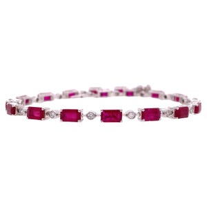 Könnte beinhalten: Ein silbernes Armband mit rechteckigen, tiefroten Edelsteinen, die mit kleinen, runden, klaren Steinen abwechseln. Das Armband ist vor einem weißen Hintergrund platziert, um das Design und die Farbe hervorzuheben.
