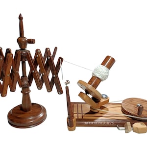 Peut inclure: Deux outils d'artisanat en bois sont présentés sur fond blanc. L'un est un cantre à fil, l'autre un rouet. Le cantre à fil est brun foncé et de conception réglable. Le rouet est de couleur marron clair.