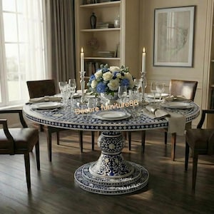 May include: A round dining table with a blue and white patterned top and a decorative pedestal base. The table is set with plates, silverware, and a floral centerpiece. Brown leather chairs surround the table.