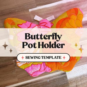 May include: A white ceramic mug with a black handle and the text "But First, Coffee" in a bold, black font. The mug is set against a blurred background, suggesting a cozy setting.