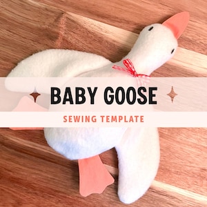 Pode incluir: Um brinquedo de pelúcia de ganso bebé branco com pés e bico cor de laranja, com uma pequena fita aos quadrados vermelhos e brancos atada ao pescoço. A imagem inclui o texto BABY GOOSE SEWING TEMPLATE com dois pequenos ícones de estrelas.