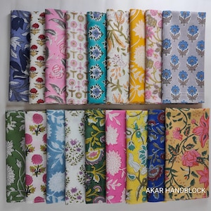 May include: A collection of rectangular fabric swatches arranged in two rows, featuring diverse floral and botanical block-print patterns in colours including blue, pink, yellow, green, and white. The text AKAR HANDBLOCK is visible.