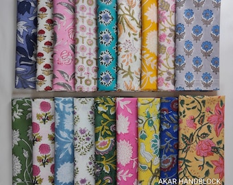 May include: A collection of rectangular fabric swatches featuring diverse floral and botanical block print patterns in vibrant colours including yellow, pink, blue, green, and purple. The text AKAR HANDBLOCK is printed in the bottom right corner.