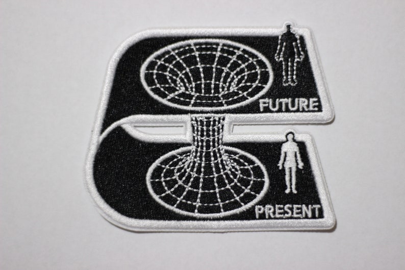 May include: Black and white embroidered patch depicting a person standing in front of a black hole, with the words "FUTURE" and "PRESENT" below.