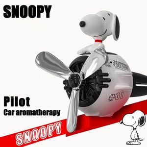 Ambientador con forma de coche piloto de Snoopy, hélice giratoria, aromaterapia y clip para rejilla de ventilación.