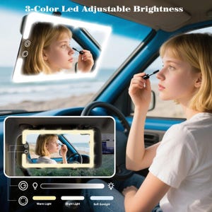 May include: A car visor mirror with integrated LED lights. The mirror features adjustable brightness settings and has a rectangular shape with rounded corners. The text "3-Color Led Adjustable Brightness" is at the top. A person is applying makeup in the car.