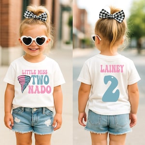 May include: A young child wearing a white t-shirt and denim shorts. The front of the shirt says "Little Miss Two Nado" with a tornado graphic. The back of the shirt says "Lainey 2". The child is wearing heart-shaped sunglasses and a black and white bow.