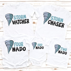 May include: White t-shirts with a blue and black tornado graphic. The shirts have text that reads "Storm Watcher", "Storm Chaser", "Four Nado", "Bro Nado", and "Two Nado". The shirts are short-sleeved.